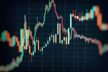 Borsa grafiği öndeki ekranda. Finans ve yatırım konsepti. Seçici odak.