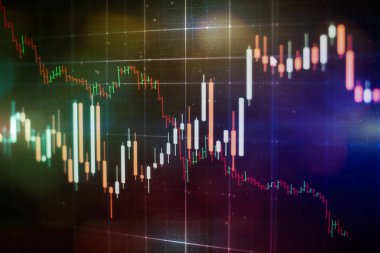 Borsa grafiği öndeki ekranda. Finans ve yatırım konsepti. Seçici odak.