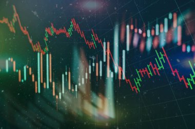 Borsa grafiği öndeki ekranda. Finans ve yatırım konsepti. Seçici odak.