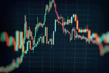 Borsa grafiği öndeki ekranda. Finans ve yatırım konsepti. Seçici odak.