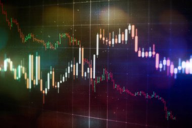 Borsa grafiği öndeki ekranda. Finans ve yatırım konsepti. Seçici odak.