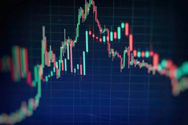 Borsa grafiği öndeki ekranda. Finans ve yatırım konsepti. Seçici odak.