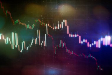 Borsa grafiği öndeki ekranda. Finans ve yatırım konsepti. Seçici odak.