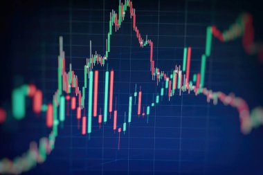 Borsa grafiği öndeki ekranda. Finans ve yatırım konsepti. Seçici odak.