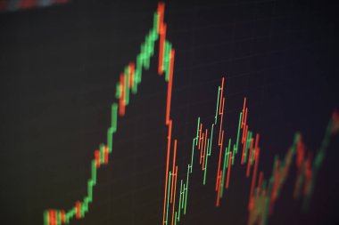 Borsa grafiği öndeki ekranda. Finans ve yatırım konsepti. Seçici odak.