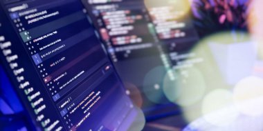 Çağdaş bir teknoloji ortamında çift monitörlerdeki programlama kodunun ayrıntılı görünümü, yazılım geliştirme ve dijital verimliliği vurguluyor.