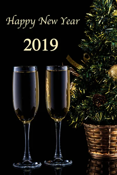 New Year's celebration background with a pair of glasses of champagne and Christmas tree. — Stock Photo, Image