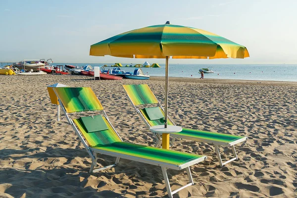 Parasoll och schäslonger på stranden i Rimini i Italien.. — Stockfoto