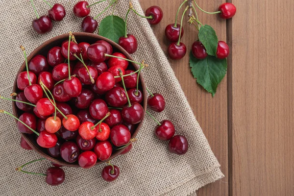 Cereza dulce fresca en un plato sobre una mesa de madera . —  Fotos de Stock