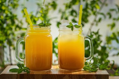 Yeşil bir arka plan üzerinde buz ve nane ile şeftali kokteyli veya çay.