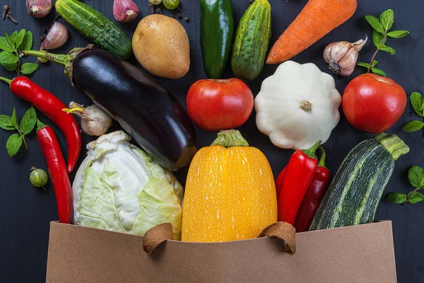 Bag of fresh vegetables on a black wooden table. — Stock Photo, Image