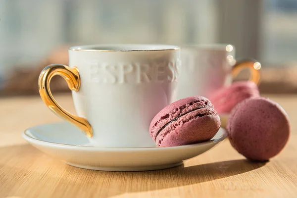 Café e macaroons um bom cartão de manhã em uma mesa de madeira — Fotografia de Stock