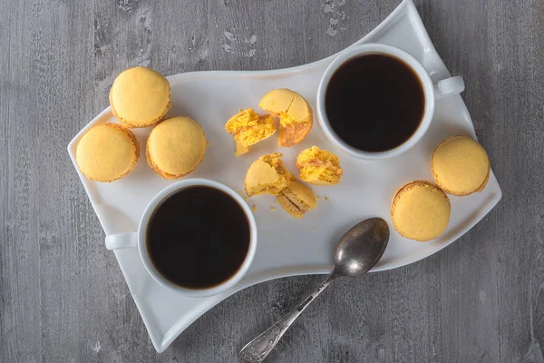 Kaffee und Makronen auf einem alten Holztisch. — Stockfoto