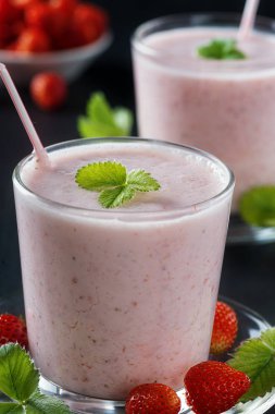  Çilekli smoothie ya da siyah kırsal arka planda cam bardakta milkshake kahvaltı ve atıştırmalık sağlıklı yiyecekler.