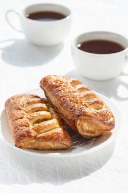 Kurabiyeler ve kahve fincanı beyaz ahşap masada..