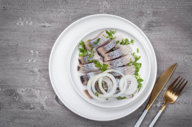 Beyaz tabakta soğanlı lezzetli tuzlu ringa balığı. Kırsal biçim.