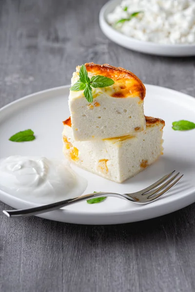  Üzümlü süzme peynir güveci ve tahta gri arka planda bir fincan süt. Süzme peynir güveci..