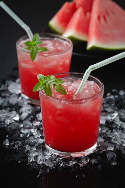 Summer cold drink with watermelon and mint on a black wooden background.	