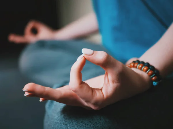 Close-up de mãos de mulheres com pulseiras meditando em pose de lótus dentro de casa. Gyan mudra. Yoga, conceito de religião . — Fotografia de Stock