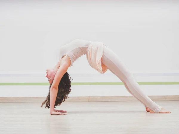 Wanita muda yang menawan berlatih yoga di ruang kelas studio minimalis ringan. Gadis yang melakukan urdhva dhanurasana dan peregangan. Konsep gaya hidup kesehatan . — Stok Foto