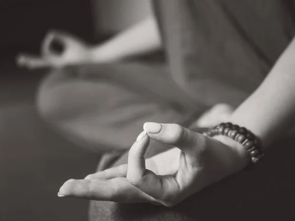 Primer plano de las manos de las mujeres con pulseras meditando en la pose de loto en el interior. Gyan Mudra. Yoga, concepto de religión. Blanco y negro — Foto de Stock