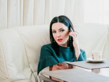 Kadın mutfakta telefonda konuşuyor. Geçici oturum smartphone sahip güzel olgun genç kadın profesyonel. Beyaz model.