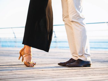 Genç çekici dans latin bachata deniz ya da okyanus yakın çift. Güneş ışığı arka plan. Yaz saati, romantik bir sahne. Profesyonel dansçılar dans edenlerin bacaklarını.