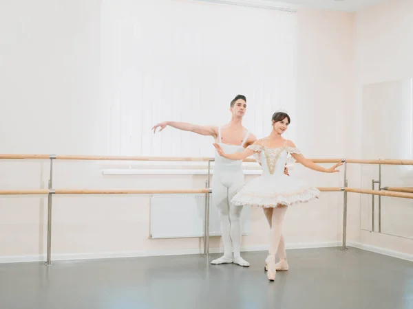 Professional, emotional ballet dancers practicing in the gym or hall with minimalism interior. Couple dancing a sensual dance before performance.