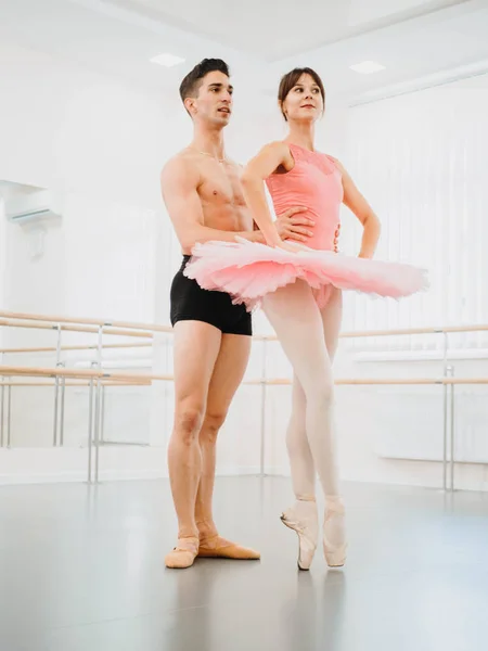Rehearsal in the ballet hall or studio with minimalism interior. Young professional sensual dancer\'s couple in beautiful costumes dancing together.