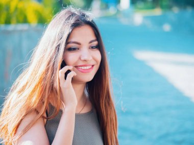 Onu telefonda konuşan kadın. Teknoloji, smartphone kavramı. Kadın konuşma bir arkadaşım var. Kız oryantal yüzü gülen ve söz.