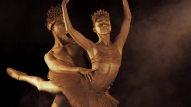 Profesyonel, duygusal bale dansçıları ile cinsel çift Kral ve Kraliçe altın vücut sanatı ile gerçekleştirdiği koyu duman sahnede kron. Altın parlayan cilt. Ağır çekim