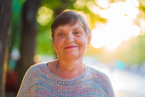 Mooi portret van glimlachen leeftijd vrouw op de straat zomer. Kaukasische grootmoeder camera kijken — Stockfoto