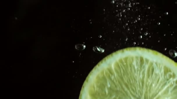 Fresh lemon slice plunging in water, slow motion — Stock Video