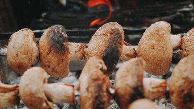Bir ızgarada pişmiş bir şiş üzerinde büyük mantar