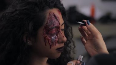 Makyöz halloween olun UPIN studio kız olun. Cadılar Bayramı yüz sanat. Kadın profesyonel yağlıboya İspanyol kız yüzünde geçerlidir. Savaş-boya kan, yaralar ve yaralar. Ağır çekim