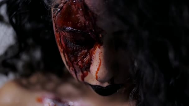 Scary portrait of young girl with Halloween blood makeup. Beautiful latin woman with curly hair looking into camera in studio. Living dead greasepaint. Slow motion — Stock Video