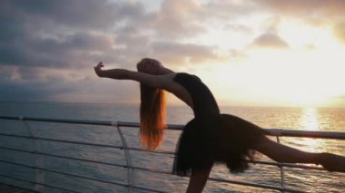 Dans eden Balerin Bale tutu ve pointe setin okyanus ya da deniz plaj yukarıda üzerinde güzel sahne. Güzel sarışın genç kadın uzun saçlı uzanan pratik ve egzersizleri. Ağır çekim.