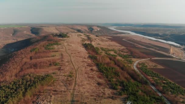 Вид з повітря на безпілотник. Політ над осіннім схилом з деревами та річкою. Прекрасні зелені гірські хребти. Літаючи над високою стежкою, відкриваючи вражаючі долини з ялиною — стокове відео