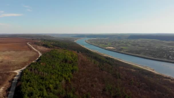 Αεροφωτογραφία από drone. Πετώντας πάνω από το φθινόπωρο πλαγιά με δέντρα και ποτάμι. Όμορφη πράσινη κορυφογραμμές. Πετώντας πάνω από υψηλή μονοπάτι, αποκαλύπτοντας θεαματικές κοιλάδες με έλατο — Αρχείο Βίντεο