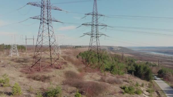 Elektrischer Hochspannungsmast gegen den Himmel. Luftaufnahme von der Drohne bis zu Stromleitungen. Naturlandschaft, sonniger schöner Tag — Stockvideo