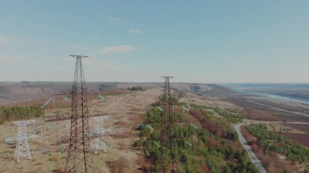 Elektrische hoog voltage pyloon tegen hemel. Luchtfoto van drone aan elektrische leidingen. Natuur-landschap, mooie zonnige dag — Stockvideo