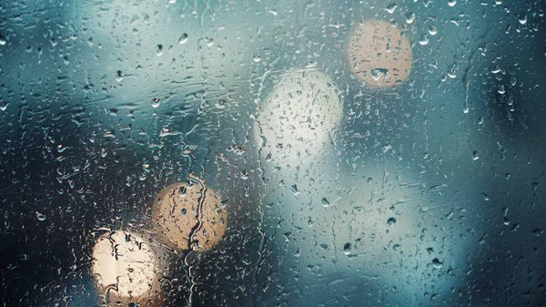 Vista da vicino delle gocce d'acqua che cadono sul vetro. Pioggia che scende dalla finestra. Stagione delle piogge, autunno. Gocce di pioggia scendono, cielo grigio — Foto Stock