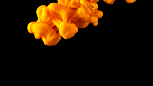 Oranžový inkoust v černém pod vodou. Barva žlutá barva reaguje ve vodě vytváří abstraktní oblačnosti. Lze použít jako přechody, přidán do moderních projektů, umělecká pozadí.