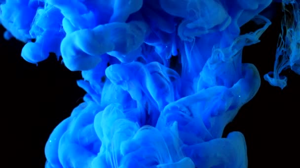 Μελάνι μπλε λάμψη στο νερό γυρίσματα με κάμερα υψηλής ταχύτητας. Σπινθηρίζον μπογιά έπεσε, αντιδρά, δημιουργώντας αφηρημένα σύννεφο σχηματισμούς και μεταμόρφωση σε μαύρο. Τέχνη φόντα. — Αρχείο Βίντεο