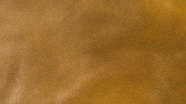 Yüksek hızlı kamera ile çekim su altın mürekkeple. Altın glitter kum veya toz soyut bulut formasyonları metamorfoz oluşturma. Sanat arka planlar. Makro görünümü.