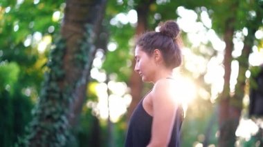 Genç güzel kadın oryantal görünümü tropikal Adası'nda günbatımı ışık yoga pratik ile. Spor, filtness, sağlıklı yaşam konsepti. Siyah spor giyim kız. 4k.