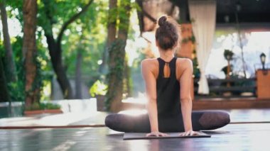 Oryantal görünüm yoga samakonasana tropik ada ahşap güvertesinde yalnız pratik olan kadın. Kız Split sicim yapıyor. Spor, fitness, sağlıklı yaşam konsepti.