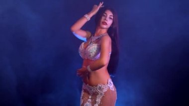 Egzotik kostüm kadında cinsel yarı çıplak vücut hareketleri. Mavi neon duvarda dans seksi geleneksel Oryantal Dansöz kızı. Müslümanlar, günaha kavramı. Muhteşem show