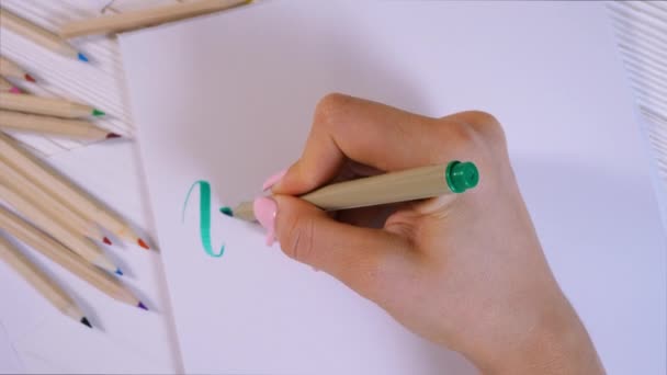 Inspire. Calligrapher writes with green marker word on white paper. Calligraphy. Ornament font. The art of lettering. Graphic design, handwriting, creation concept. 4k — Stock Video