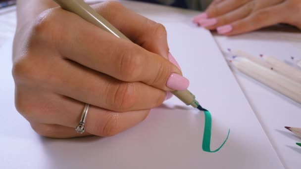 Las prácticas de los estudiantes de calígrafo al escribir palabras inspiran con marcadores verdes en el lienzo. Artista creativo freelancer trabajando en el proyecto en el estudio en casa. Letras, concepto de escritura. 4k — Vídeo de stock